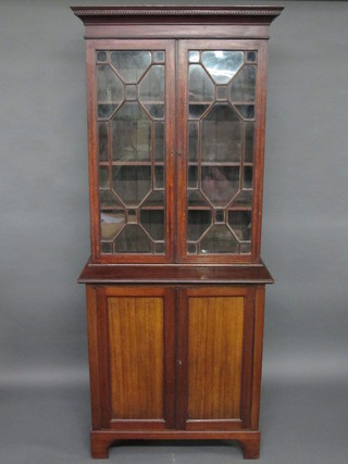 A 19th Century mahogany bookcase on cabinet with moulded and dentil cornice, fitted adjustable shelves enclosed by astragal glazed doors, the base fitted a cupboard  enclosed by a pair of panelled doors, raised on bracket feet 36"