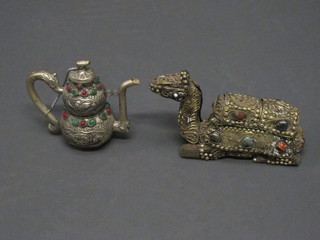 An Eastern embossed white metal teapot 5" set hardstones  together with a figure of a seated camel 7"