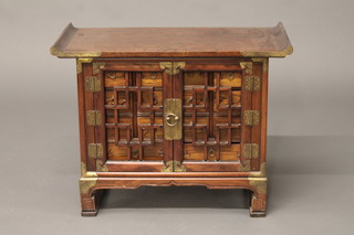 An Oriental hardwood cabinet fitted 12 short drawers above 2  long drawers enclosed by grilled panelled doors 25"