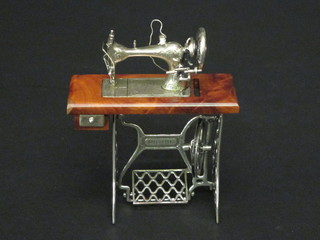 A miniature silver model of a treadle operated sewing machine  marked 800