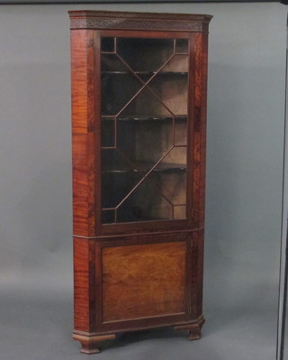 A Georgian style mahogany double corner cabinet with moulded and dentil cornice, fitted shelves enclosed by astragal glazed  panelled doors, the base fitted a cupboard enclosed by a panelled  door, raised on ogee bracket feet 35"
