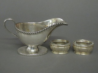 A silver plated sauce boat with gadrooned border and a pair of oval white metal salts