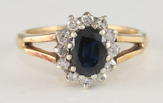 A 9ct gold dress ring set a sapphire supported by diamonds