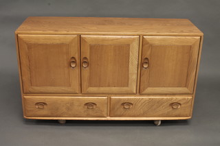 An Ercol light elm sideboard fitted 3 cupboards, the base fitted 2  long drawers 51"