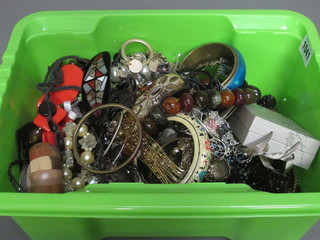 A green crate containing a collection of costume jewellery