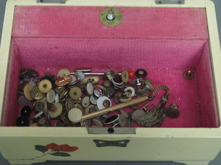 A lacquered jewellery box containing a collection of various studs, cufflinks, etc