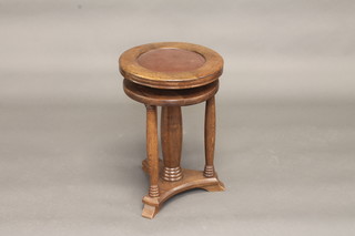 A Victorian oak revolving piano stool with turned column and triform base