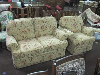 A Marks & Spencers two seat settee upholstered in floral material together with a matching armchair