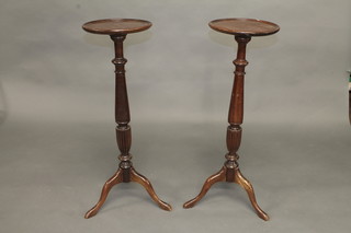 A pair of circular Georgian style turned mahogany torcheres, raised on pillar and tripod bases 12"