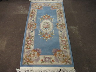 A blue ground and floral patterned Chinese rug 74" x 36"