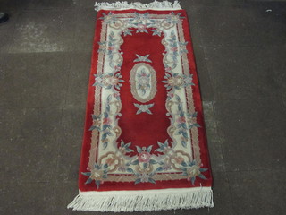A red ground and floral patterned Chinese rug 48" x 30"