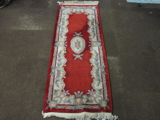 A red ground and floral patterned Chinese runner 73" x 28"