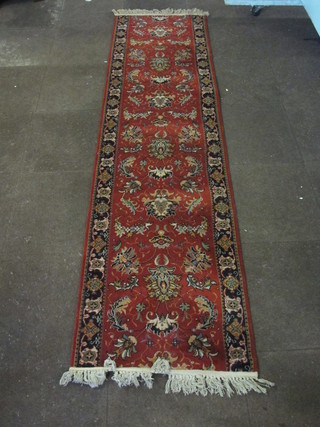 A red ground Persian style machine made runner 107" x 28"