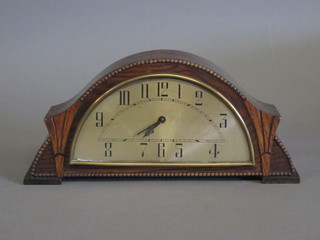 An Art Deco 8 day chiming mantel clock with silvered chapter ring and Roman numerals contained in a walnut case