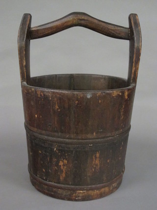 A circular wooden well bucket with handle