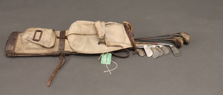 A canvas and leather golf bag containing a hickory shafted putter, 2 drivers marked 2 and 3, 3 Cecil Thomson irons and a Cecil  Thomson Royal Eastbourne no.6, a Jack Gadal Bombay no.6  iron, and a James Baid Pinsplitter