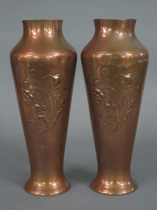 A pair of Art Nouveau embossed copper vases decorated poppies, raised on spreading feet 15"