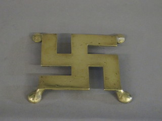 A brass trivet in the form of a Swastika 5"