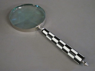 A large magnifying glass with chequer handle