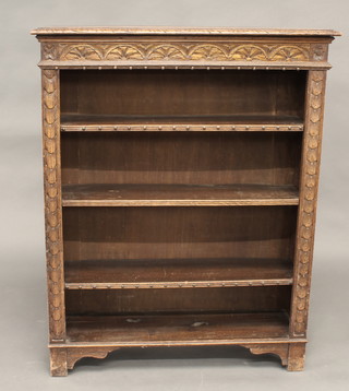 A Victorian carved oak bookcase fitted adjustable shelves raised  on a platform base 36"