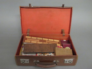 A leather attache case containing a collection of playing cards, cribbage boards etc