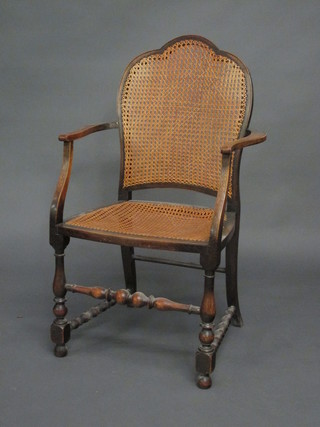 An oak open arm carver chair with woven cane seat and back,  raised on turned and block supports