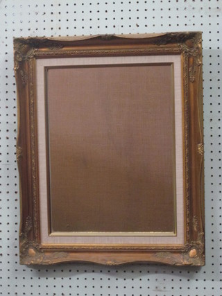 A rectangular plate mirror contained in a decorative gilt frame 21"