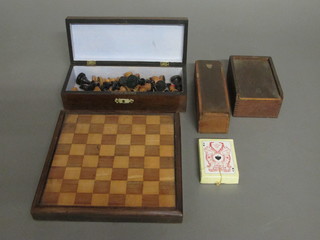 A wooden chess set, 2 wooden sets of draughts, a chequer board  and a set of playing cards