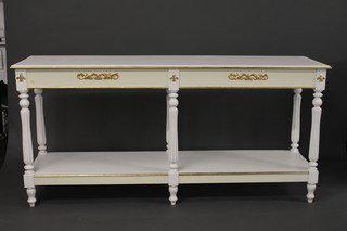 A rectangular white painted 2 tier side table with gilt decoration  raised on turned and reeded supports 73"