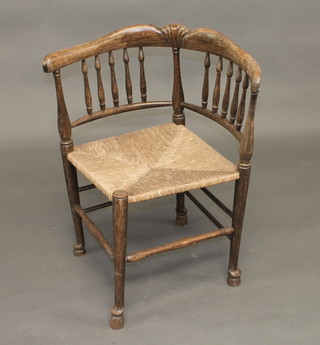 A beech framed tub back corner chair with woven rush seat,  raised on turned supports