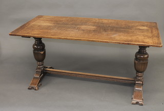 An oak refectory style dining table, raised on cup and cover  supports with H framed stretcher 60"