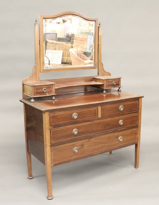 An Edwardian inlaid mahogany dressing chest with arch shaped bevelled plate mirror, the base fitted 2 glove drawers above 2  long and 2 short drawers, raised on square tapering supports 42"