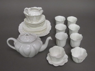 A Shelley 21 piece white glazed tea service comprising 2 square  9" plates - 1 cracked, 6 tea plates, 6 1/2" - cracked, 7 saucers - 6  cracked and 8 cups - 3 cracked, sugar bowl, milk jug and a small  dish, the reverse marked RD27102