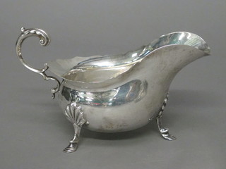 A Georgian style silver sauce boat with wavy border and C scroll handle, raised on 3 hoof feet, Sheffield 1918 by Walker & Hall  6.25 ozs