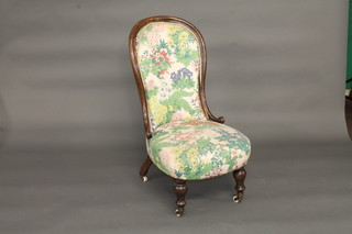 A Victorian mahogany spoon back nursing chair with upholstered  seat and back, raised on turned supports