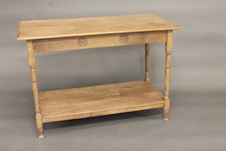 A rectangular honey oak 2 tier side table, raised on turned supports 42"