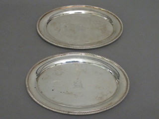 A pair of oval silver plated dishes with armorial decoration 7 1/2"
