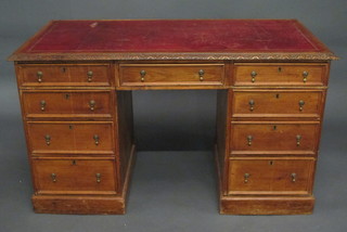 A walnut kneehole pedestal desk with inset tooled leather writing surface, fitted 1 long and 8 short drawers 48"
