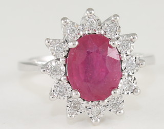 An 18ct white gold dress ring set an oval cut ruby surround by diamonds