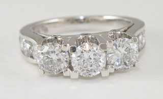 An 14ct white gold dress ring set 3 diamonds and with diamonds  to the shoulders, approx 2.85ct