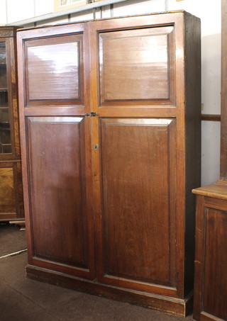 A 19th Century mahogany cabinet, the shelved interior enclosed  by panelled doors, raised on a platform base 49"