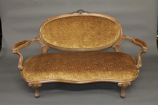 A Victorian carved walnut show frame sofa upholstered in gold coloured material, raised on cabriole supports 60"