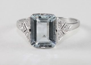 A lady's 18ct white gold dress ring set a rectangular cut aquamarine and with 6 diamonds to the shoulders,
