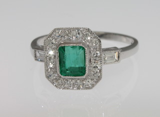 A lady's 18ct white gold dress ring set a square cut emerald  surrounded by diamonds, approx 0.75/0.35ct