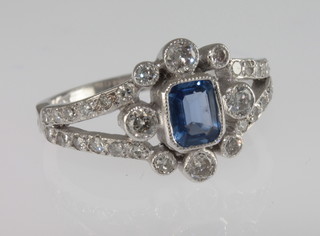 A lady's 18ct white gold dress ring set a rectangular cut sapphire surrounded by diamonds