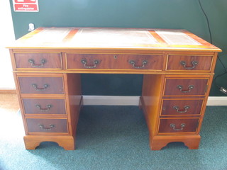 A 19th Century style yew kneehole pedestal desk with inset  tooled leather writing surface, fitted 1 long and 8 short drawers,  raised on bracket feet 48"