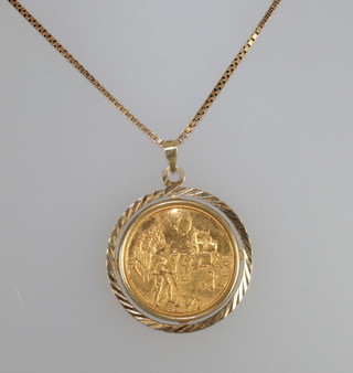 A medallion to commemorate the moon landing set as a pendant and hung on a gold box link chain