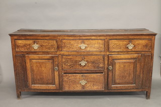 An 18th Century oak dresser base, fitted 5 drawers flanked by a pair of cupboards 72"  ILLUSTRATED