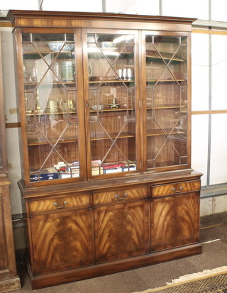 A Georgian style mahogany triple display cabinet with moulded cornice, the interior fitted adjustable shelves enclosed by astragal  glazed panelled doors, the base fitted 3 long drawers above a  triple cupboard, raised on a platform base 61"