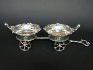 A silver plated 2 bottle wine coaster, raised on 4 wheels